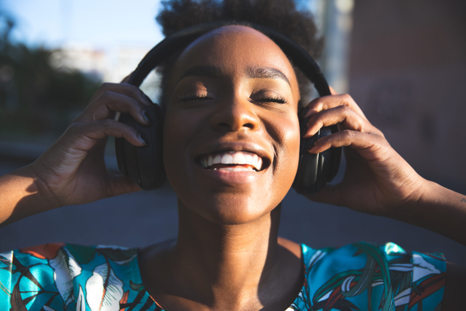 Happy woman dancing listening to music - iAwake Technologies